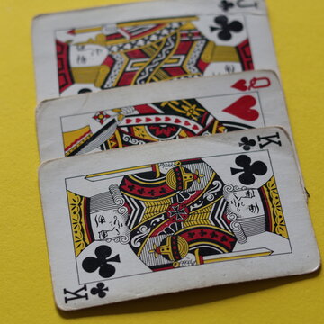 Una toma de cerca de varios cartas de p&oacute;ker viejas desgastadas  en un fondo amarillo