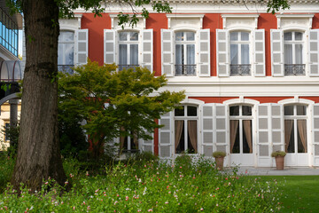 In Mont de Marsan, the stunning city hall building features classic architecture surrounded by green gardens. Visitors can admire the elegant design and peaceful atmosphere on a bright day.