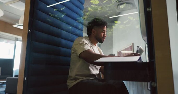 Writing, man and tablet in office pod for research notes, editor feedback and article planning. Hybrid work, journalist and tech in cubicle for proofreading draft, publishing schedule and blog review