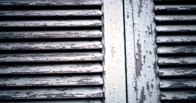Weathered wooden shutters with peeling paint, creating a rustic ambiance