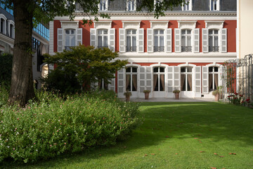 In Mont de Marsan, the stunning city hall building features classic architecture surrounded by green gardens. Visitors can admire the elegant design and peaceful atmosphere on a bright day.