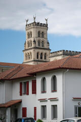 Explore the stunning architecture of the Basilica of Notre-Dame-de-Buglose, located in Saint-Vincent-de-Paul, Landes. The building showcases intricate designs against a moody sky.