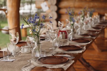 Elegant dining setup with flowers and rustic decor in a natural setting for a special gathering at dusk