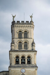 Explore the stunning architecture of the Basilica of Notre-Dame-de-Buglose, located in Saint-Vincent-de-Paul, Landes. The building showcases intricate designs against a moody sky.