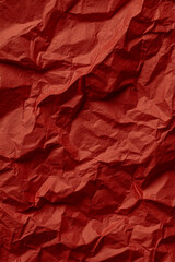 Fototapeta premium Close up textured background of crumpled red paper with deep shadows and highlights