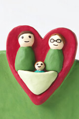 Valentine's clay, Clay couple with baby in heart shaped stroller, symbolizing love and family joy