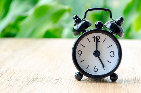 Alarm clock pointing at 5 pm with customizable background space for text or ideas. Time concept.