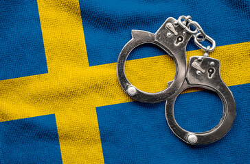 Flag of Sweden and police handcuffs. Crime and offenses in country Concept
