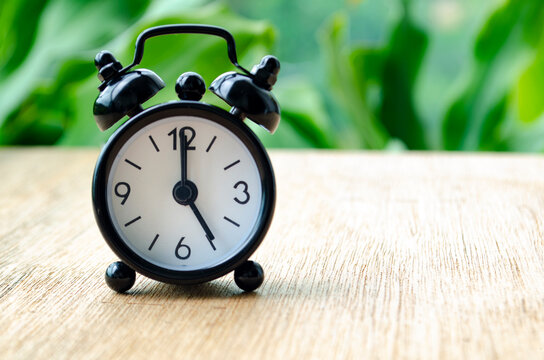 Alarm clock pointing at 5 pm with customizable background space for text or ideas.