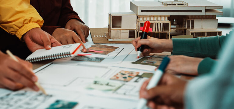 A creative team collaborates in an architectural studio, engaged in hands-on planning and sketching for innovative building designs, showcasing teamwork and professionalism. SACTR