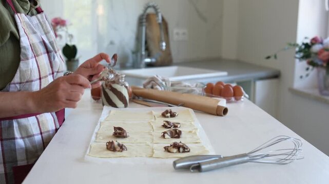 Woman Baking Cookies And Applying Chocolate Cream To The Pieces Of Dough