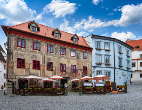 Cozy old street with tables of restaurant and ancient building with sgraffito in Cesky Krumlov, Czech Republic. Architecture and landmark of Cesky Krumlov