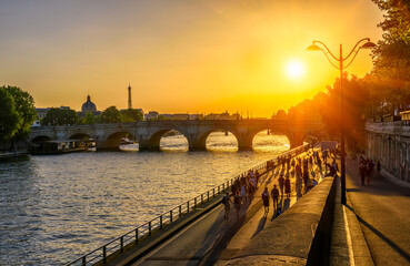Sunset view of embankment of Seine river, Pont Neuf is the oldest bridge across the river Seine and Eiffel Tower in Paris, France. It is one of the symbols of Paris.