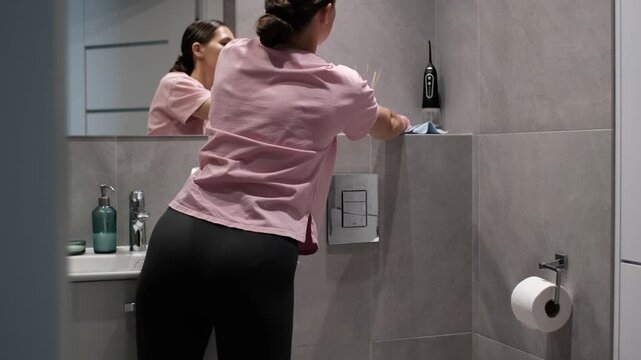 Domestic Cleaning Scene: Woman Disinfecting Bathroom