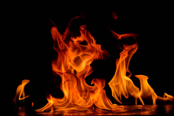 Massive wide and intense orange-red flames reaching upward against black background, showcasing...