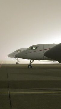 cockpit white heavy business jets aircraft parked apron fbo gat stands during dark night airport up close front panning shot area scene 