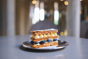 A piece of blueberry  Millefeuille on the table in cafe