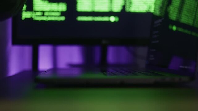 Quiet desk illuminated by soft purple glow, Serene workspace temporarily resting before coding resumes again, Peaceful environment with subdued purple lighting marking brief pause in work activity