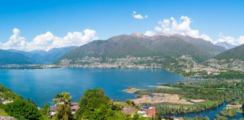 Obraz premium Scenic landscape of Lake Maggiore surrounded by mountains, viewed from Magadino, a hamlet of Gambarogno in the canton of Ticino, Switzerland.