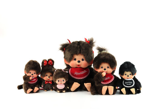 a popular classic doll toy , Monchichi or Monchhichi , Japanese cute monkey fur doll display on white table with white wall background in souvenir tourist shop in Japan