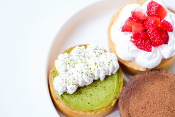 Various kinds of mini cheese tarts on a white plate