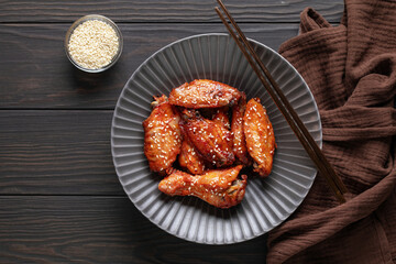 Chicken wings with teriyaki sauce and sesame seeds in a bowl on the table. Top view
