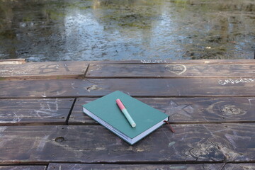 Cuaderno y lapicera sobre el Muelle 