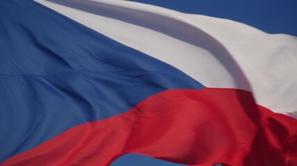 Czech Republic flag waving proudly in a gentle breeze against a clear blue sky, symbolizing national pride and identity on a bright sunny day