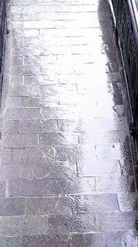 A high angle perspective. The rainwater traces intriguing patterns across the pavement.