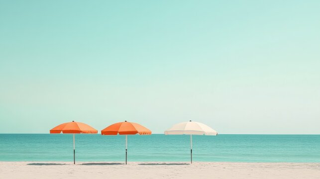 Three beach umbrellas, two orange and one white, standing on a sandy shore with turquoise ocean and clear sky - Powered by Adobe