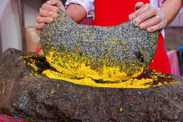 Grinding chili peppers with a mortar and pestle. Traditional food from the regions of Peru.