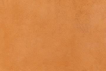 orange painted structured plaster wall in warm mediterranean color as harmonic background