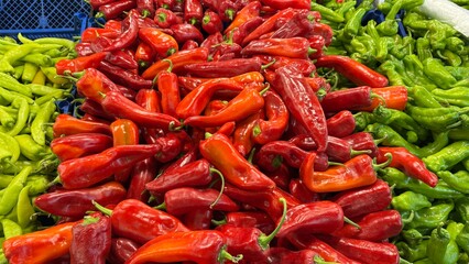 Colorful Display of Fresh Peppers at a Local Market Showcasing Vibrant Red and Green Varieties in Bright Daylight