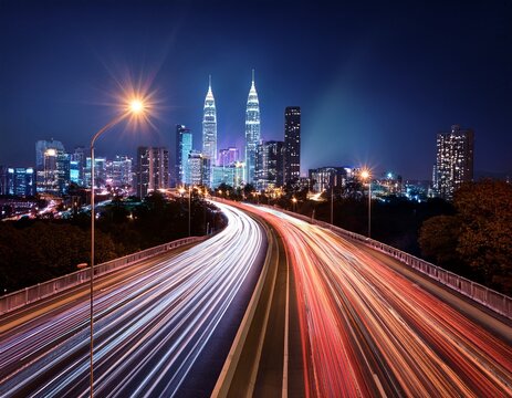 streaking light trails illuminate a highway leading to a vibrant city at night