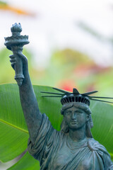 Fototapeta premium Statue of liberty with a palm frond in the background. 