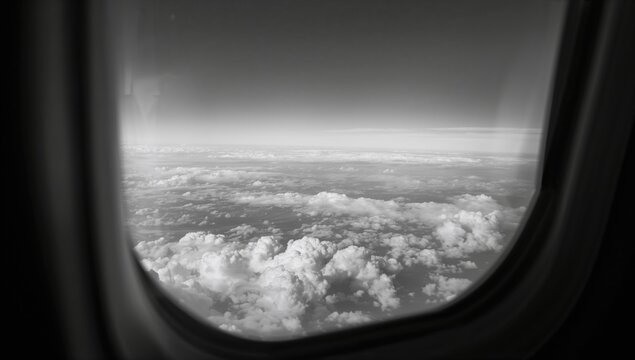 View from an airplane window, showcasing cloud formations and the earth below, highlighting the experience of travel