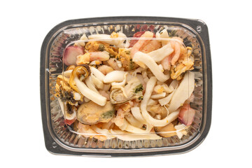 Seafood salad in a plastic container, top view, macro