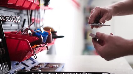 Serviceman Using A Vernier Caliper To Measure An Auto Part Against A Set Of Mechanic's Tools