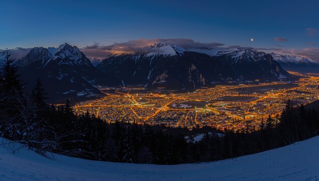 Nighttime panorama of a snowy landscape with ski areas, showcasing urban density and seasonal change
