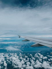 Aerial Scenic View of Airplane Wing Flying over Fluffy Cloudscape