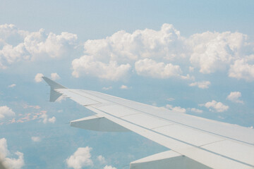 Obraz premium Aerial Sunny View of Airplane Wing Above Soft Cloudscape Journey