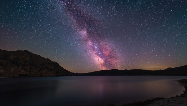 Fototapeta Milky Way Core over a Lake at Night, light pollution impact