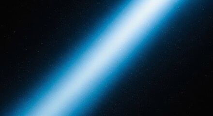 Vibrant blue light beam cuts through deep starry night sky, creating a powerful cosmic effect perfect for science fiction or abstract backgrounds.