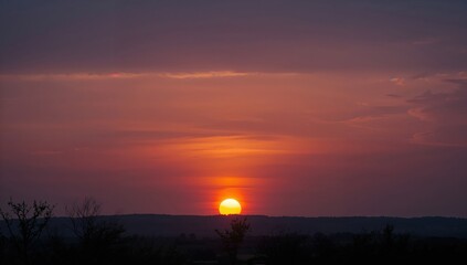 Obraz premium Sunset over the horizon, creating a warm glow on the landscape, seasonal change