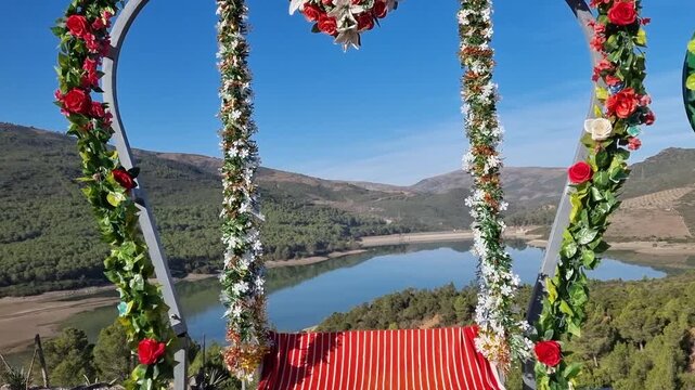 Decorative photo frames, including heart-shaped ones, set up for visitors to pose with the scenic Lac du Barrage Sed Nakhla dam in Zinat, Morocco, framed by mountains between Tetouan and Chefchaouen.
