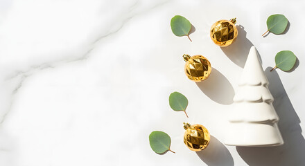 Festive Holiday Decoration Golden Ornaments and Eucalyptus Leaves on White Marble Background