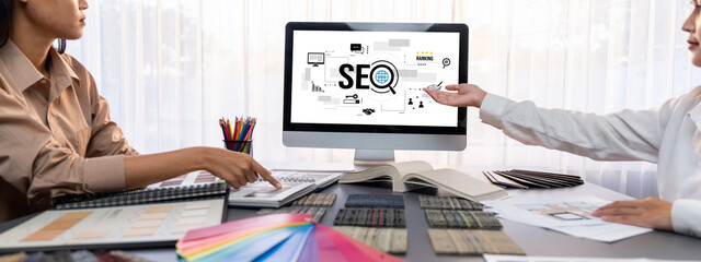 Group of interior architect designer team at table choosing various mood board samples with architecture software on laptop screen. Modern renovation and interior material selection concept. Insight