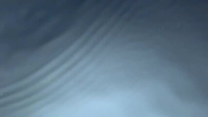 Close-up view of a calm water surface with small air bubbles and gentle ripples. Minimalist abstract texture, reflecting light and tranquility, suitable for backgrounds or design concepts. - Powered by Adobe