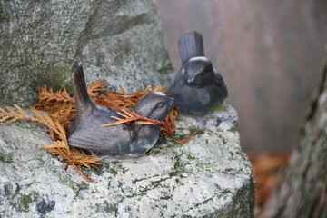 Dekoration Vögle mit Laub im, Herbst auf einem Grabstein auf dem Friedhof