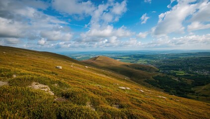 Fototapeta premium Vibrant hues of the summer sky over a lush hill landscape, ideal for nature-themed projects